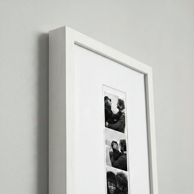 Photo strip in a white wood frame
