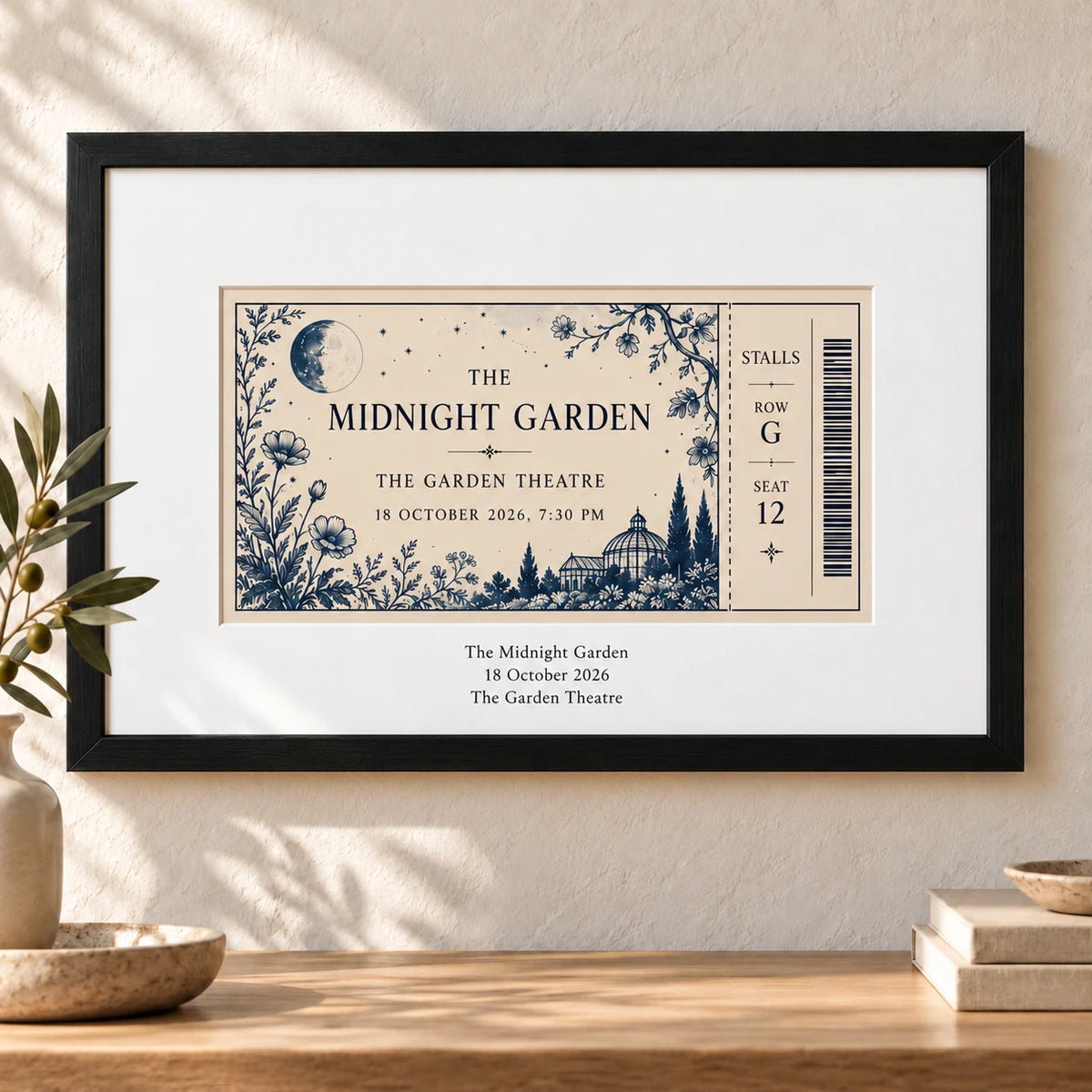 A theatre event ticket in a black landscape frame with even white mount borders and the show, date and theatre centred on the lower border