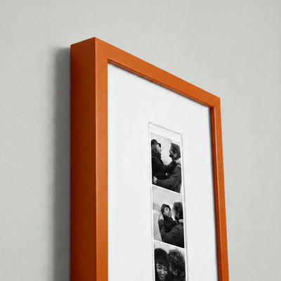 Photo strip in an orange wood frame