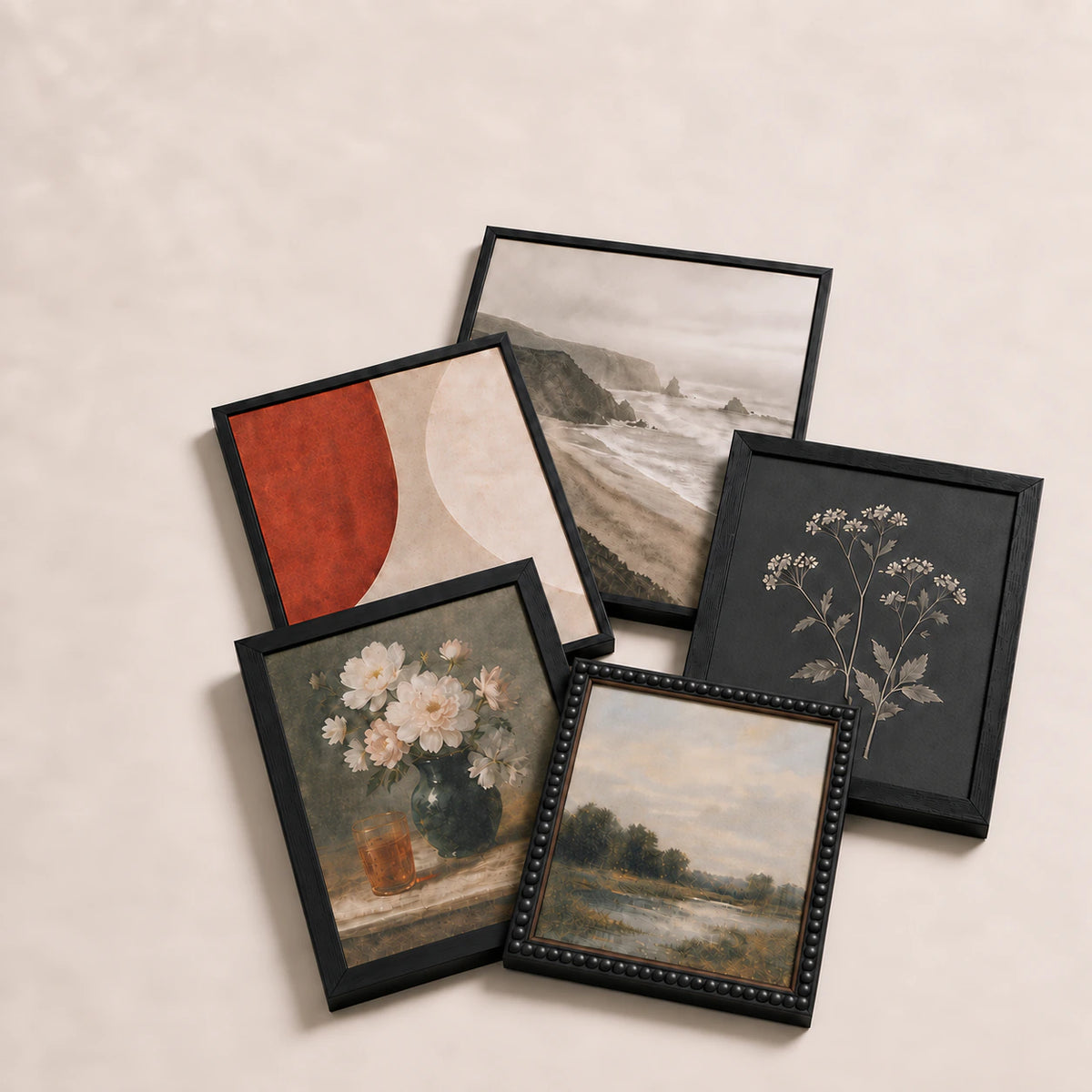 A collection of black picture frames lying flat with varied edge-to-edge artwork