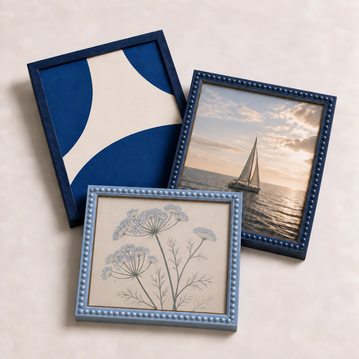 A collection of blue picture frames lying flat with varied edge-to-edge artwork