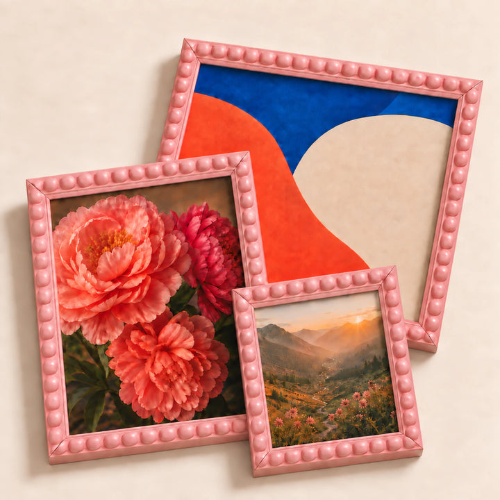 A collection of pink bobbin picture frames lying flat with varied edge-to-edge artwork