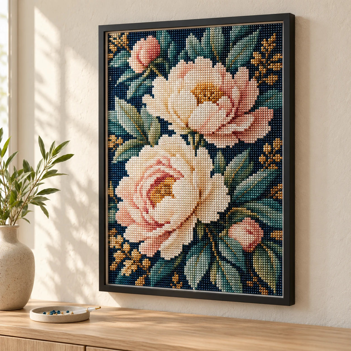 A floral diamond painting with visible raised resin beads in a slim black deep frame above an oak sideboard