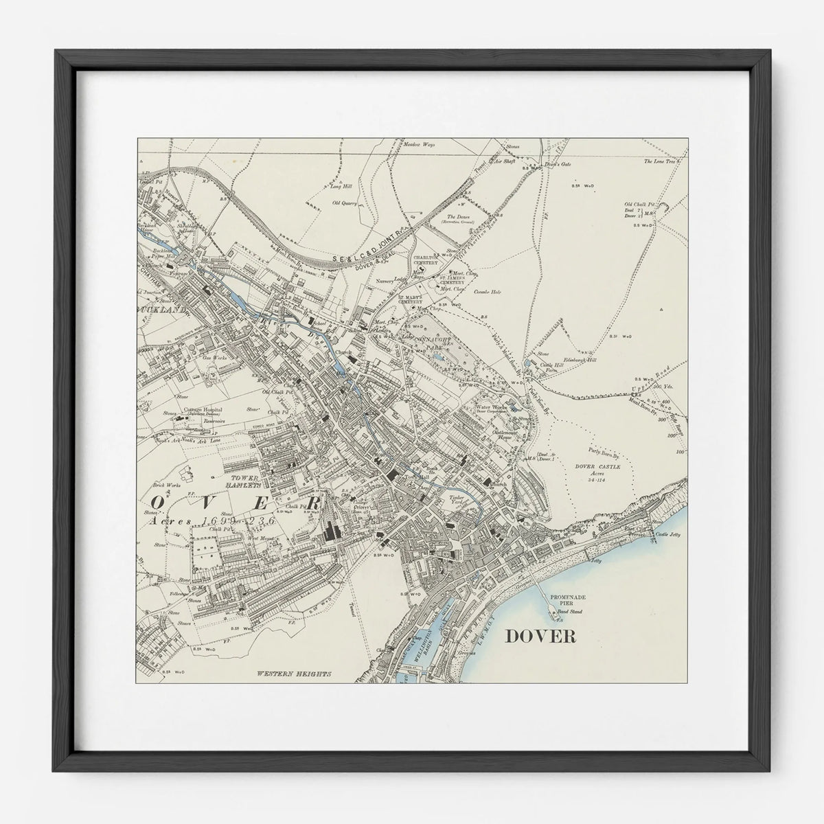 An antique town map in a black frame with a white mount