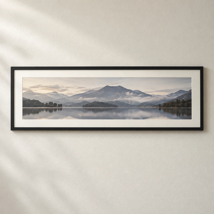 A panoramic mountain and lake photograph displayed in a wide black frame