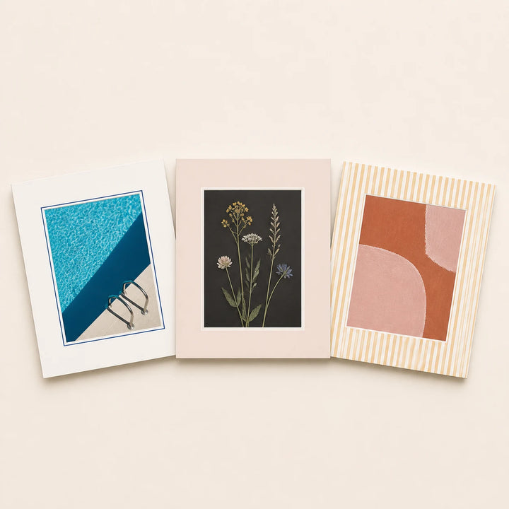 Three 5 by 7 inch picture mats in plain and patterned finishes holding varied artwork