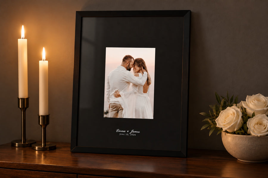 Black mat with the couple's names printed in white script, in a black frame